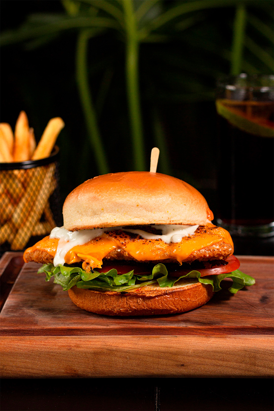 Tábua com hambúrguer ao fundo batata frita